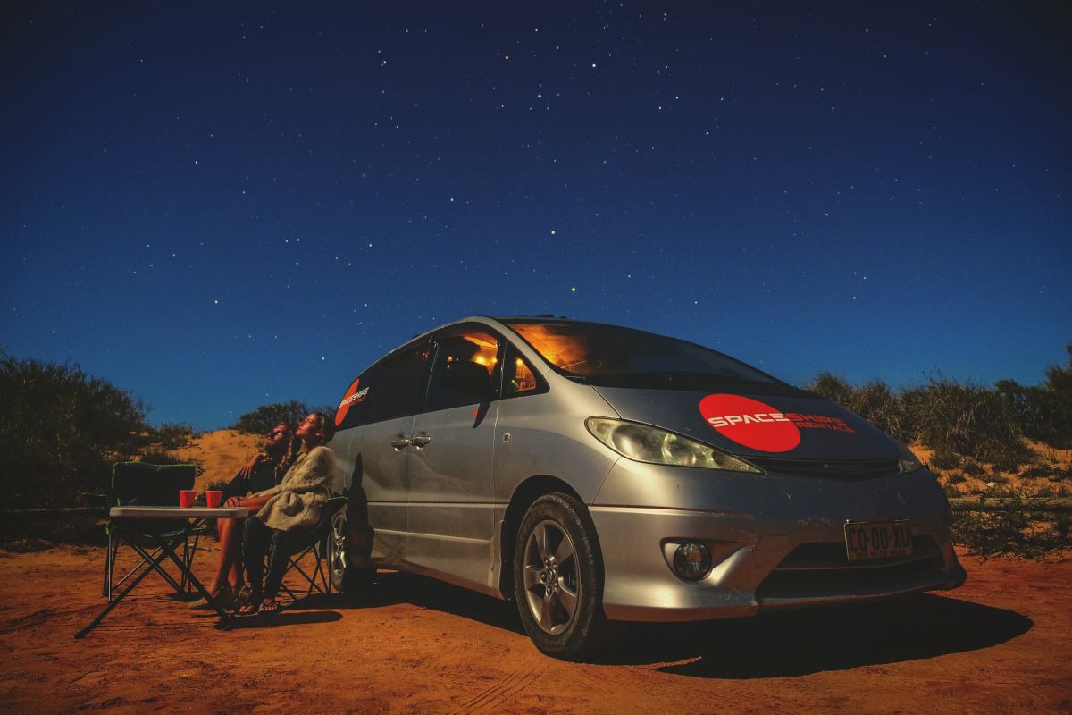 Beta 2S campervan parked at night - Space Travellers sitting next to it enjoying the starry night