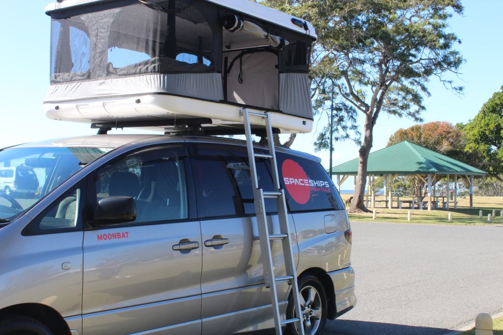 campervan parked with a pop up rooftop tent and the ladder set up
