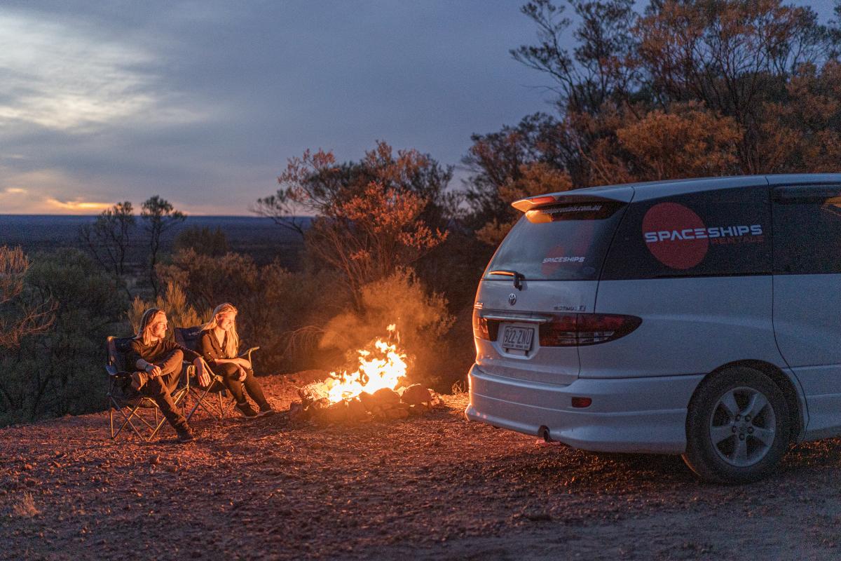 Two Space Travellers created a campfire (safely). Campervan parked on the right