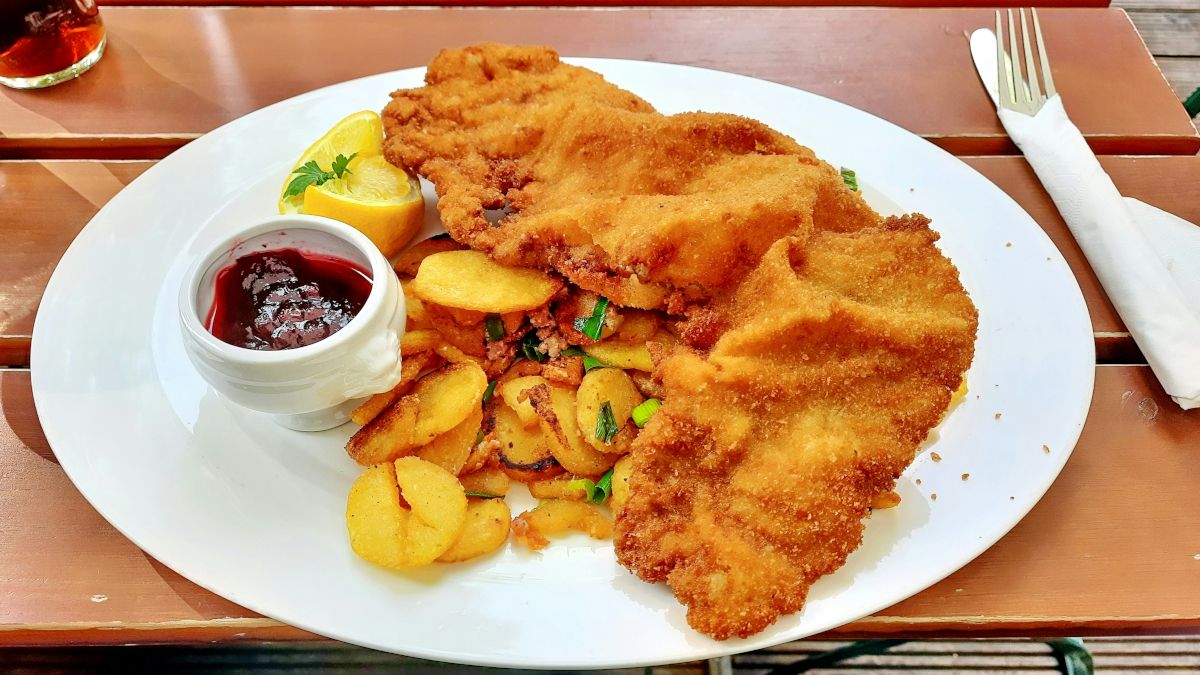 Typical German dish: schnitzel with pommes (potatoes) on a white plate