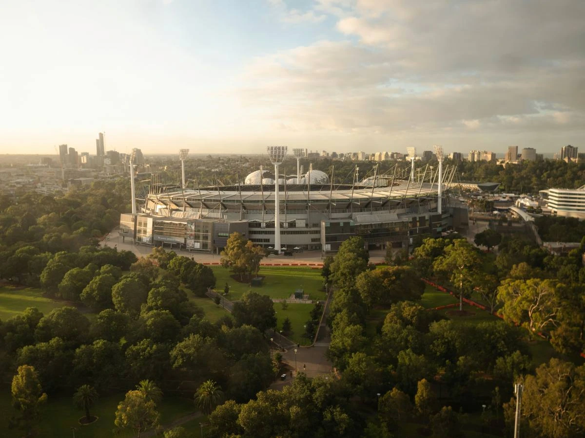 large stadium in the middle of the city surrouned by greenery