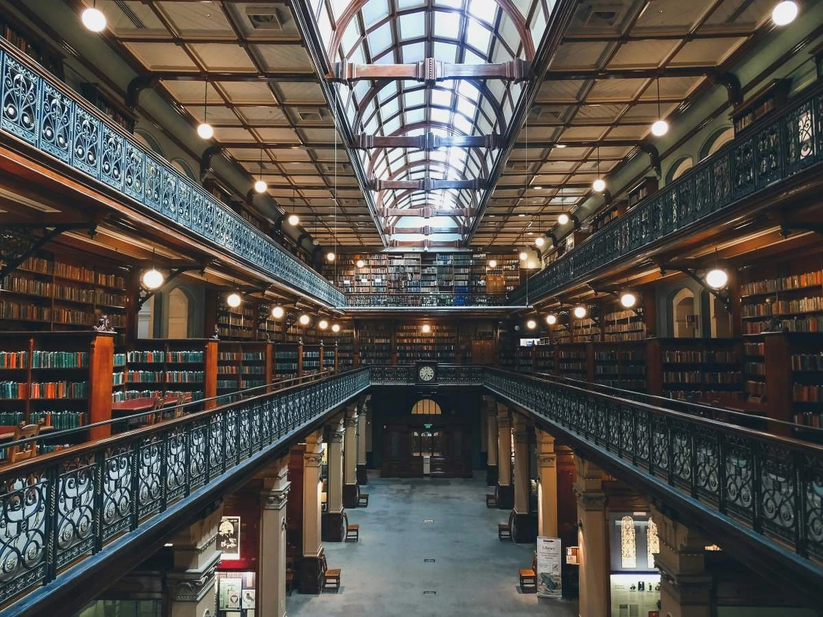 Interior view of a library 3 stories high with ornate balconies overlooking the floors below