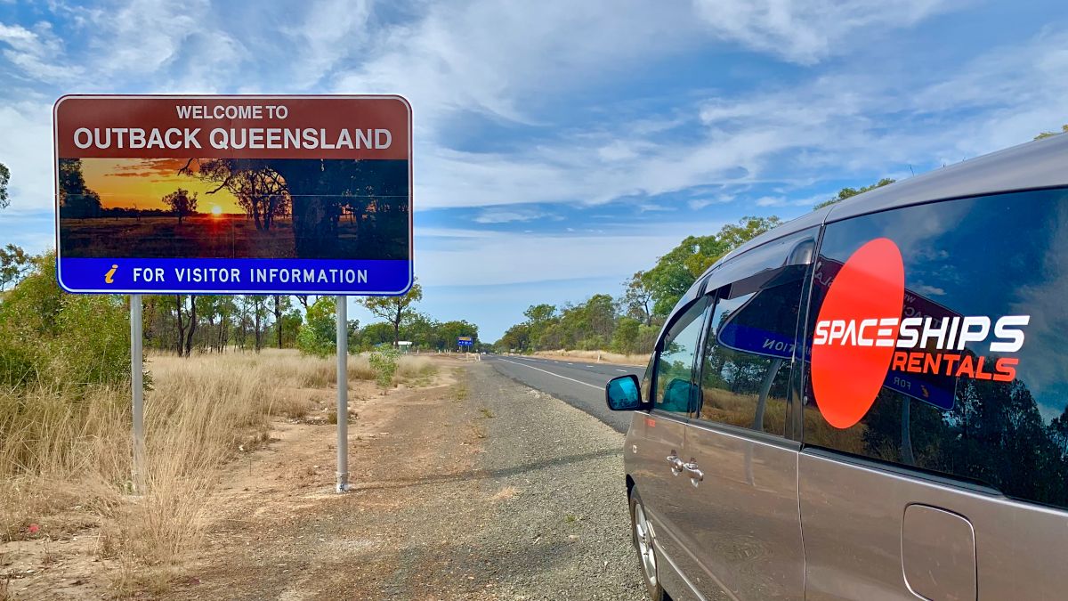 Spaceships cammpervan in front of a Queensland Outback sign