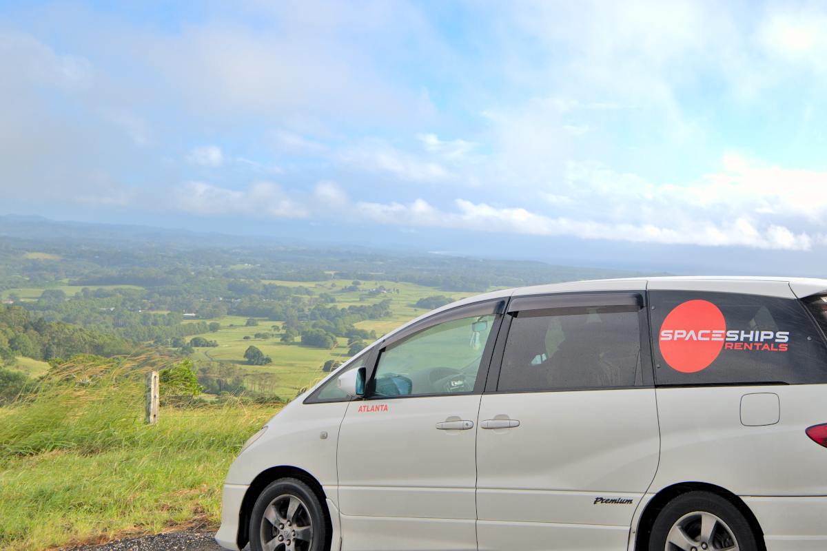 White parked campervan on a hill overlooking rural countryside